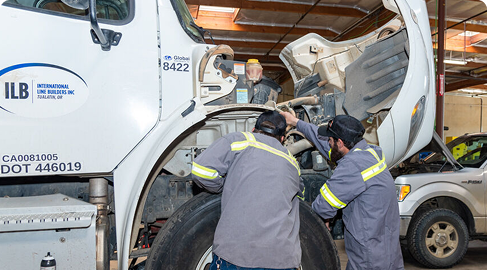 Mechanics performing DOT and BIT inspections on a truck